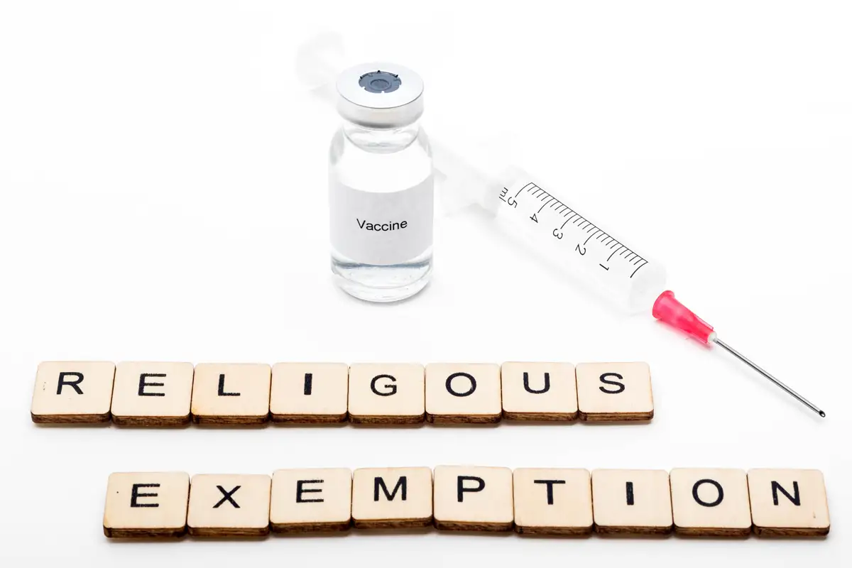 image of vaccine vial and syringe with the words religious exemption spelled out in scrabble blocks